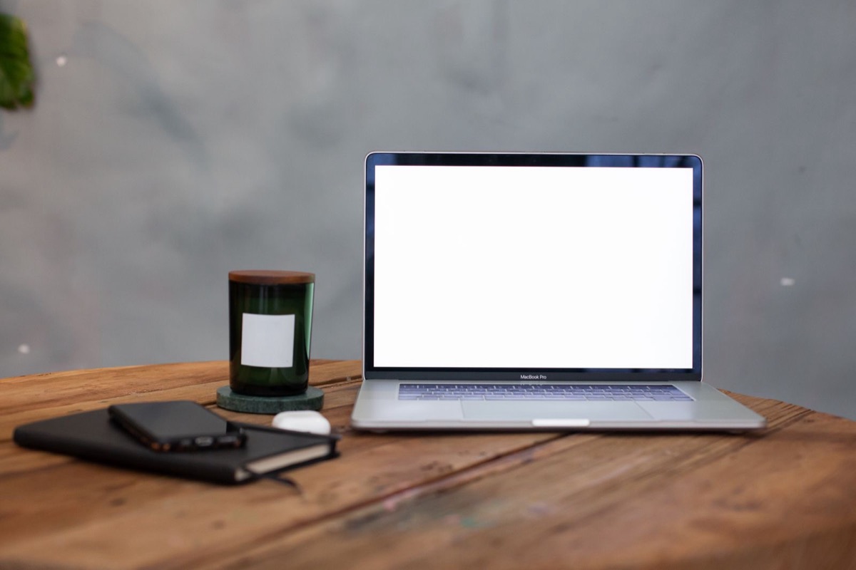 A laptop with a blank screen on a wooden table