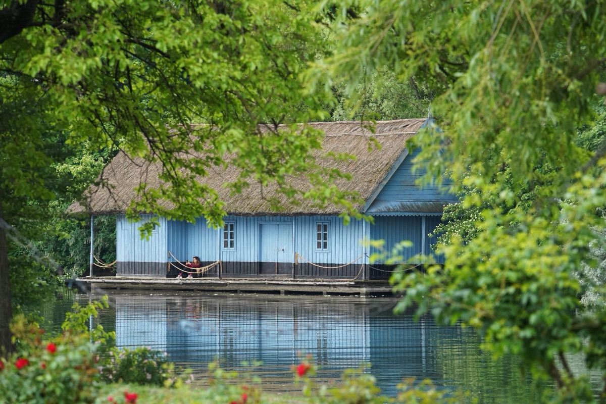 A blue wooden house on a lake in a Bucharest park